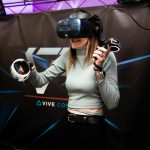 A woman immersed in a virtual reality experience, wearing a VR headset and controllers.